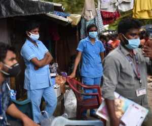 epa09503024 Health workers wait for the people at a slum as part of a door-to-door vaccination campaign during the fourth mega vaccination drive against the COVID-19 coronavirus disease, in Chennai, India, 03 October 2021. The Tamil Nadu state government organised the fourth mega COVID-19 vaccination drive to vaccinate more people across the state. So far, India has administered over 900 million cumulative COVID-19 vaccines, Union Minister for Health and Family Welfare Mansukh Mandaviya said on 02 October.  EPA/IDREES MOHAMMED