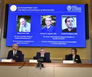 epa09518229 Goran K Hansson (C), Permanent Secretary of the Royal Swedish Academy of Sciences, Peter Fredriksson (L) and Eva Mork (R) members of the Royal Swedish Academy of Sciences, announce the Sveriges Riksbank Prize in Economic Sciences in Memory of Alfred Nobel 2021, during a press conference at the Royal Swedish Academy of Sciences in Stockholm, Sweden, 11 October 2021. L-R on screen David Card, University of California, Berkeley, USA, Joshua D. Angrist, Massachusetts Institute of Technology, Cambridge, USA and Guido W. Imbens, Stanford University, USA, are awarded the prize.  EPA/Claudio Bresciani SWEDEN OUT SWEDEN OUT
