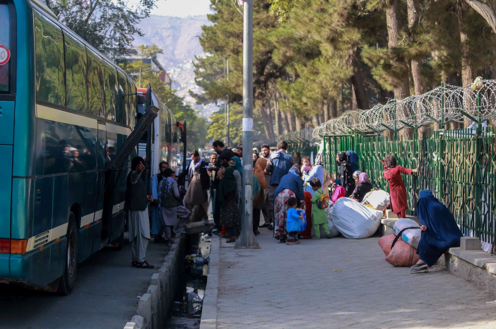 epa09518486 Afghan families, who were displaced from other parts of the country, prepare to return to their home towns, in Kabul, Afghanistan, 11 October 2021. The Ministry of Refugees and Repatriation has begun the process of returning displaced families from the capital Kabul to their home province, supporting them with transportation and cash assistance.  Lack of international recognition remains a pressing problem for the Taliban, who are not only geopolitically isolated but are also facing a major cash crunch after international financing institutions froze most of the funds Afghanistan has long relied upon for economic stability.  EPA/STRINGER