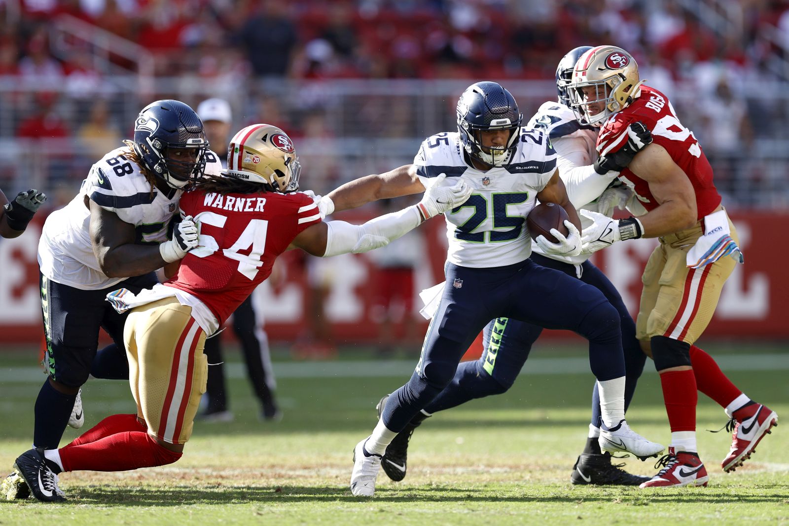 epa09504799 Seattle Seahawks running back Travis Homer (C) eludes a tackle by San Francisco 49ers middle linebacker Fred Warner (2-L) during the second half of the NFL American Football game between the Seattle Seahawks and San Francisco 49ers at Levi's Stadium in Santa Clara, California, USA, 03 October 2021.  EPA/JOHN G. MABANGLO