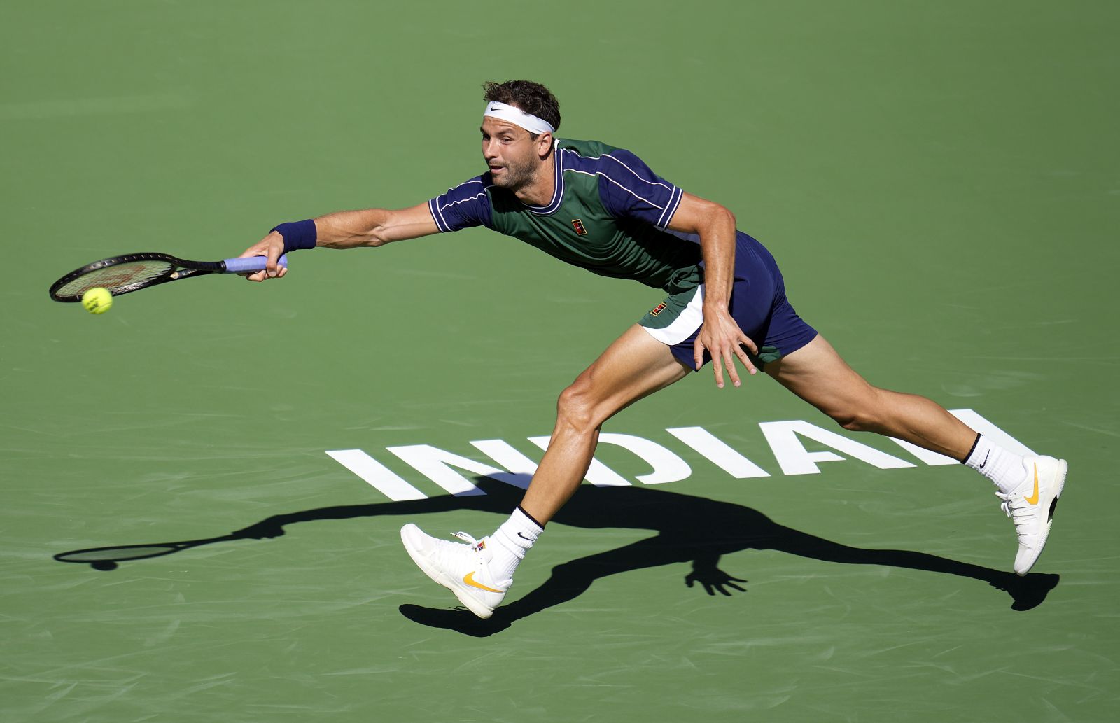 epa09522542 Grigor Dimitrov of Bulgaria hits a return in his match against Daniil Medvedev of Russia at the BNP Paribas Open tennis tournament at the Indian Wells Tennis Garden in Indian Wells, California, USA, 13 October 2021.  EPA/RAY ACEVEDO