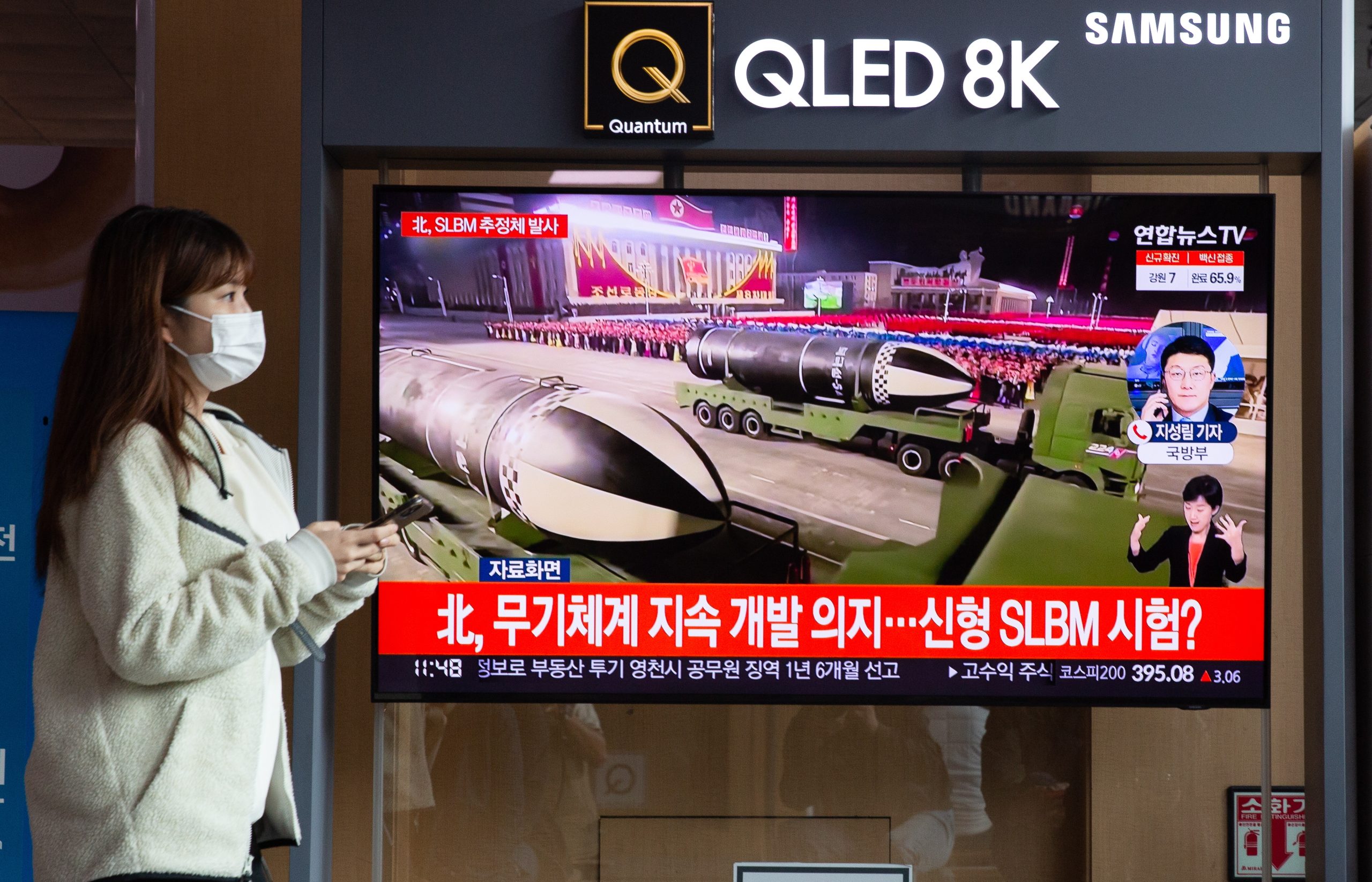 epa09531365 A woman stands near a TV screen showing a news program reporting on North Korea's latest missile launch with file footage at a station in Seoul, South Korea, 19 October 2021. According to South Korea's Joint Chiefs of Staff (JCS), North Korea fired an unidentified projectile toward the East Sea on 19 October.  EPA/JEON HEON-KYUN