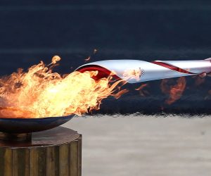 epaselect epa09531745 Greek actress Xanthi Georgiou, playing the role of the High Priestess, lights the Olympic Torch during the handover ceremony of the Olympic Flame for the Beijing 2022 Winter Olympics at the Panathenaic Stadium in Athens, Greece, 19 October 2021.  EPA/YANNIS KOLESIDIS