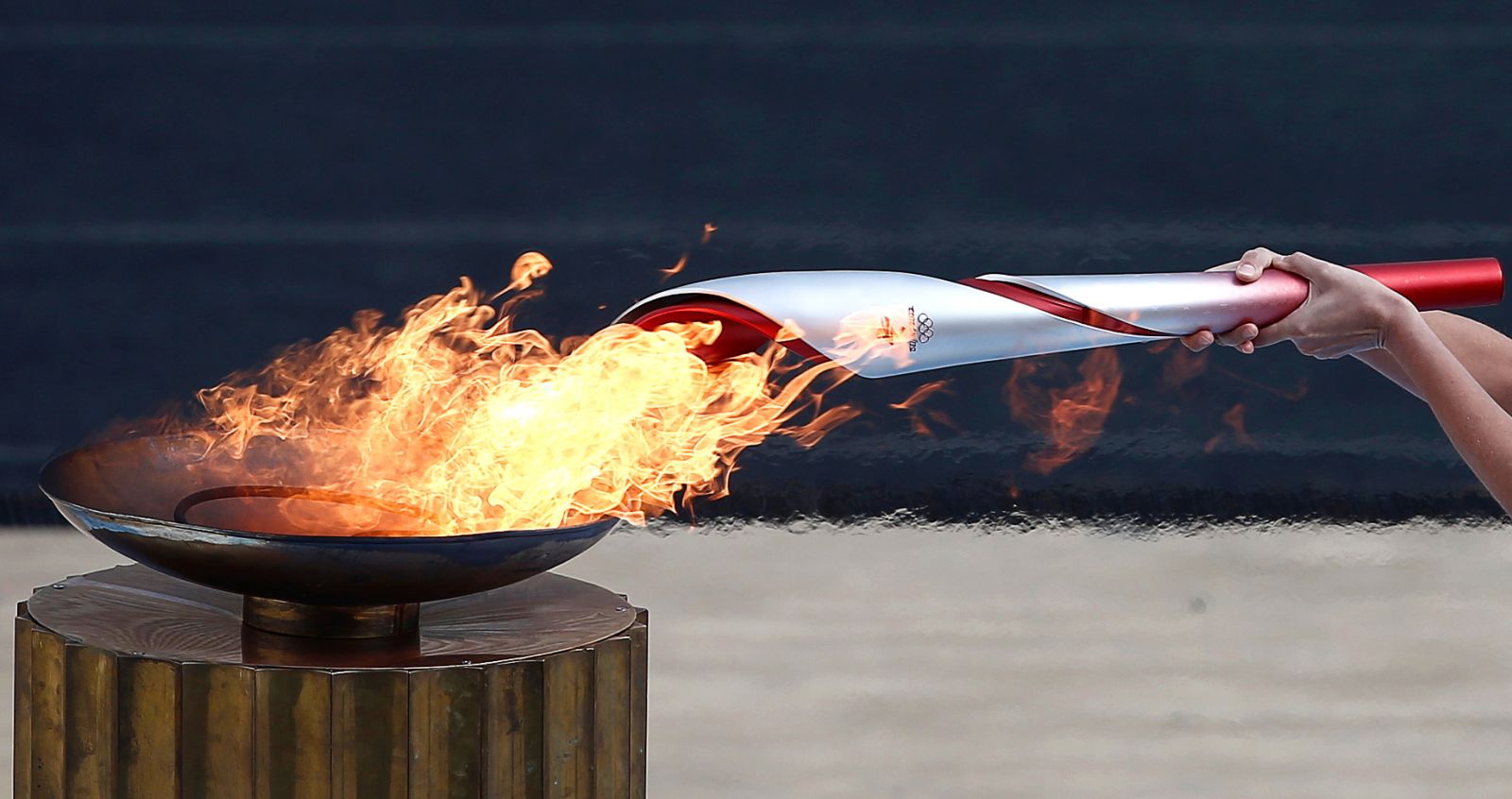 epaselect epa09531745 Greek actress Xanthi Georgiou, playing the role of the High Priestess, lights the Olympic Torch during the handover ceremony of the Olympic Flame for the Beijing 2022 Winter Olympics at the Panathenaic Stadium in Athens, Greece, 19 October 2021.  EPA/YANNIS KOLESIDIS