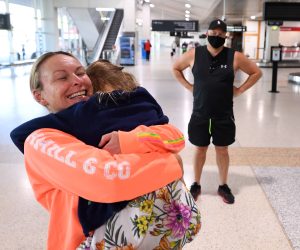 epa09533867 Melanie (L) and her daughter are reunited after spending two months apart after Melanie returned on flight QF427 at the Qantas Domestic Arrivals terminal, at Melbourne Airport, in Melbourne, Victoria, Australia, 20 October 2021. Domestic flights between Victoria and New South Wales (NSW) have resumed on the day with fully vaccinated travellers from NSW no longer required to isolate.  EPA/JAMES ROSS AUSTRALIA AND NEW ZEALAND OUT