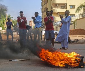 epa09545014 Sudanese protester chant near burning tires during a demonstration in the capital Khartoum, Sudan 25 October 2021. Sudan's military launched a coup attempt, and arrested the Prime Minister Abdalla Hamdok and other senior ministers and civilian members of the Transitional Sovereignty Council during early morning raids, as thousands of people gather for protest the attempt in the capital, Khartoum.  EPA/MOHAMMED ABU OBAID