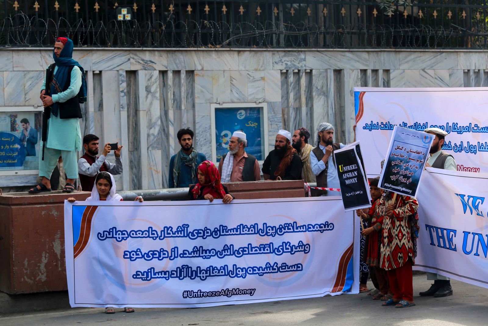epa09485682 Afghans hold banners and placards as they demand the US to unfreeze the Afghan assets and money it has seized after Taliban took over, during a protest in Kabul, Afghanistan, 24 September 2021. The US administered had frozen billions in Afghan gold, investments and foreign currency reserves parked in the United States. The economic crisis threatened to push 97 percent of the 40 million people into poverty by mid-2022, the United Nations has warned.  EPA/STRINGER