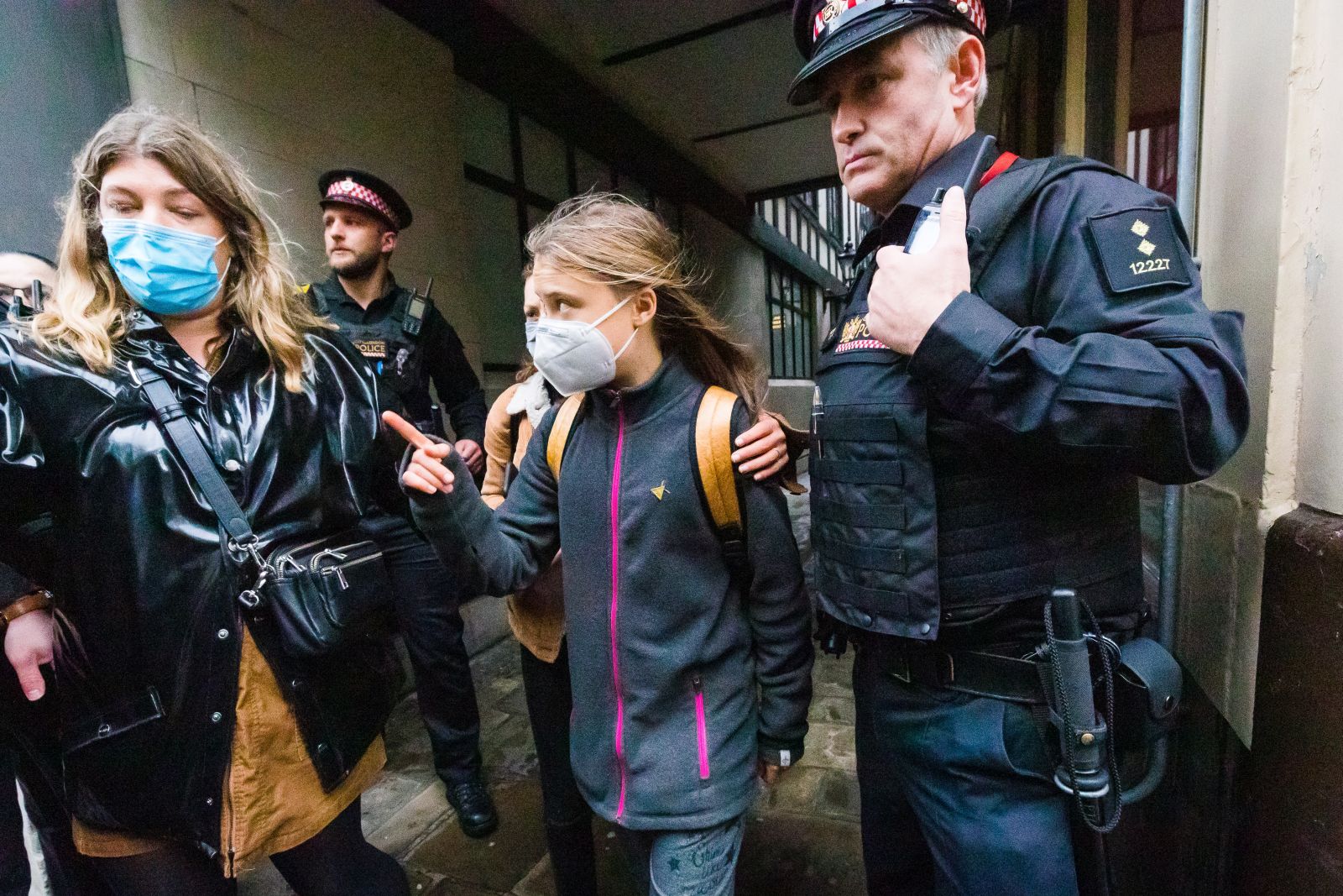 epa09552336 Swedish environmental activist Greta Thunberg (C) is escorted to a taxi by police after joining environmental protesters outside of the Standard Chartered Bank in the City of London, Britain, 29 October 2021. Protests are taking place in the capital ahead of climate change conference COP26 in Glasgow.  EPA/VICKIE FLORES