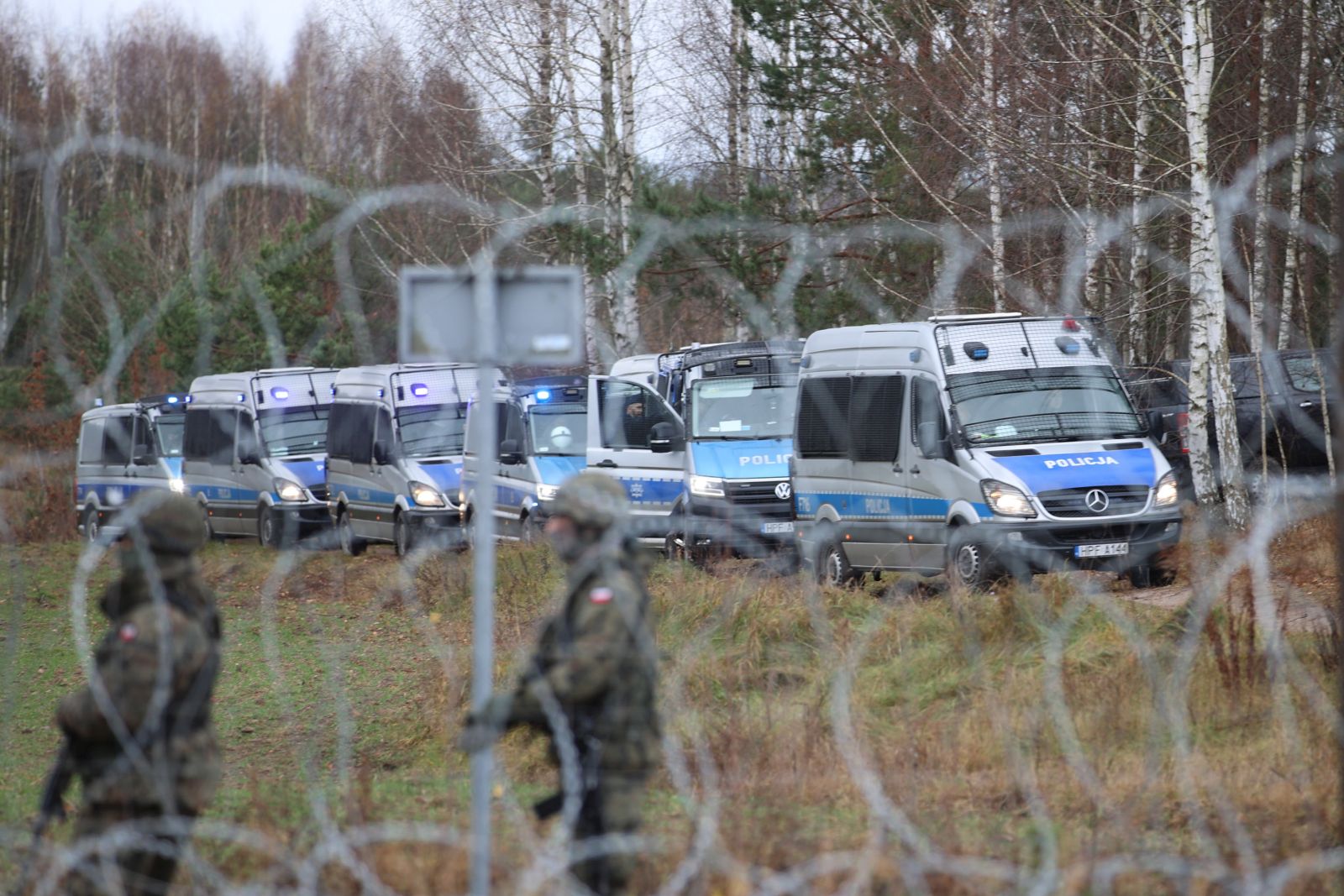 epa09572066 A handout photo made available by Belta news agency shows Polish servicemen patrolling as migrants gather on the Belarusian-Polish border in the Grodno region, Belarus, 08 November 2021 (issued 09 November 2021). According to the State Border Committee of Belarus, there are more than two thousand people near the border, including women and children, who want to obtain asylum in the European Union, 'and they do not consider the territory of the Republic of Belarus as a place of stay.' Against this background, the Polish authorities announced preparations for a breakthrough across the border. The territory is guarded by several thousand employees of the Polish special services. The migration crisis at the border of Belarus has been going on since the spring of 2021. Belarus President Alexander Lukashenko said that after the introduction of new EU sanctions against Minsk, the Belarusian authorities will no longer interfere with the movement of illegal migrants to the European Union.  EPA/LEONID SCHEGLOV / HANDOUT  HANDOUT EDITORIAL USE ONLY/NO SALES