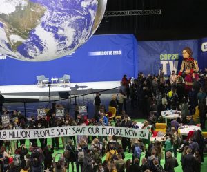 epa09572554 Delegates and participants gather around Little Amal (C), in the Hydro during the COP26 UN Climate Summit in Glasgow, Britain, 09 November 2021. Little Amal is the giant puppet of a 3.5 metre-tall living artwork of a young Syrian refugee child on 'The Walk', travelling 8,000km in 2021 in support of refugees across Turkey, Greece, Italy, France, Switzerland, Germany, Belgium and the UK to focus attention on the urgent needs of young refugees. The 2021 United Nations Climate Change Conference (COP26) runs from 31 October to 12 November 2021 in Glasgow.  EPA/ROBERT PERRY