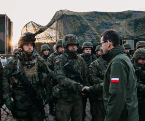 epa09572684 A handout photo made available by Chancellery of the Prime Minister shows 
Polish Prime Minister Mateusz Morawiecki (R), during a meeting with soldiers and officers of the services involved in securing the Polish border with Belarus in the region of Kuznica, eastern-Poland, 09 November 2021. On 08 November morning, the media published information about a large group of migrants planning to cross the Belarusian border with Poland. The Ministry of National Defense informed in the afternoon that the services of the Ministry of Interior and Administration and soldiers had managed to stop the first mass attempt to cross the border. Currently, migrants have set up a camp in the Kuznica region.  EPA/ADAM GUZ / CHANCELLERY OF PRIME MINISTER HANDOUT  HANDOUT EDITORIAL USE ONLY/NO SALES