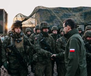 epa09572684 A handout photo made available by Chancellery of the Prime Minister shows 
Polish Prime Minister Mateusz Morawiecki (R), during a meeting with soldiers and officers of the services involved in securing the Polish border with Belarus in the region of Kuznica, eastern-Poland, 09 November 2021. On 08 November morning, the media published information about a large group of migrants planning to cross the Belarusian border with Poland. The Ministry of National Defense informed in the afternoon that the services of the Ministry of Interior and Administration and soldiers had managed to stop the first mass attempt to cross the border. Currently, migrants have set up a camp in the Kuznica region.  EPA/ADAM GUZ / CHANCELLERY OF PRIME MINISTER HANDOUT  HANDOUT EDITORIAL USE ONLY/NO SALES
