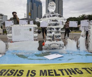 epa09573409 A melting ice statue of a kid is seen as activists hold placards during a climate change protest in Jakarta, Indonesia, 10 November 2021. A number of environmental activists from environmental organisation Greenpeace staged a protest demanding the government to accelerate actions on fighting the climate change and reducing the greenhouse emissions. Environmental activists and leaders are gathered in Glasgow at the 2021 United Nations Climate Change Conference (COP26) running from 31 October to 12 November 2021.  EPA/MAST IRHAM