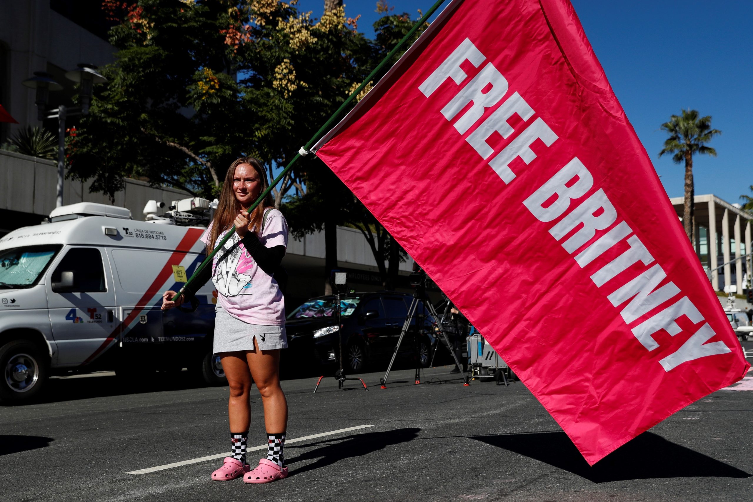 epa09579524 Alexandra Foertschbeck holds a 'Free Britney' flag during a rally outside a hearing concerning the US singer Britney Spears’ conservatorship at the Stanley Mosk Courthouse in Los Angeles, California, USA, 12 November 2021.  EPA/CAROLINE BREHMAN