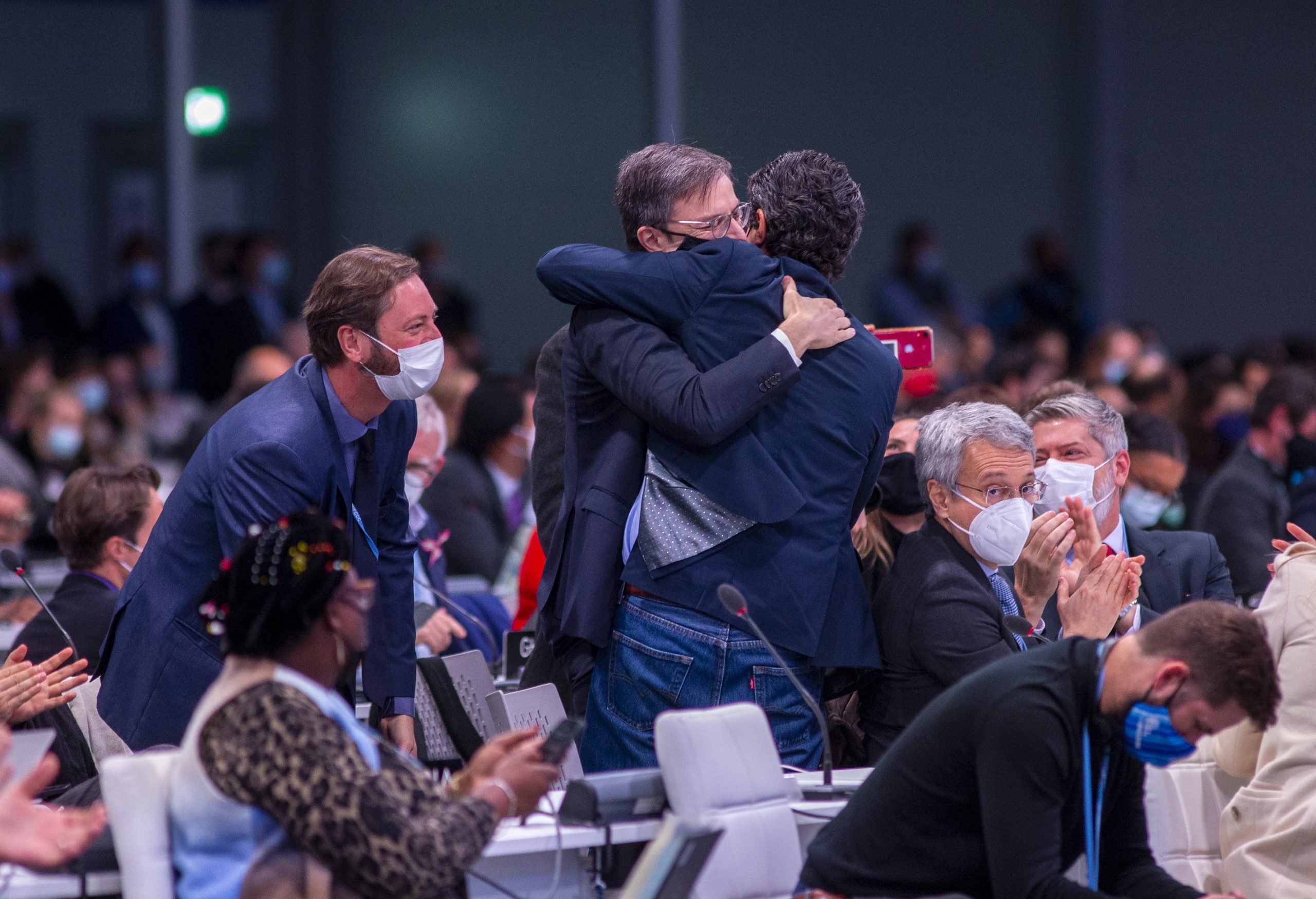epa09580887 Delegates celebrate the success of the event during the Plenary session of the COP26 UN Climate Change Conference in Glasgow, Britain, 13 November 2021. The 2021 United Nations Climate Change Conference (COP26) runs from 31 October to 13 November 2021 in Glasgow.  EPA/ROBERT PERRY