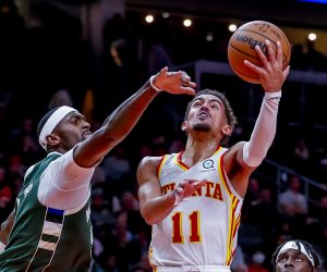 epa09582666 Atlanta Hawks guard Trae Young (R) in action against Milwaukee Bucks center Bobby Portis (L) during the second half of the NBA basketball game between the Milwaukee Bucks and the Atlanta Hawks at State Farm Arena in Atlanta, Georgia, USA, 14 November 2021.  EPA/ERIK S. LESSER  SHUTTERSTOCK OUT
