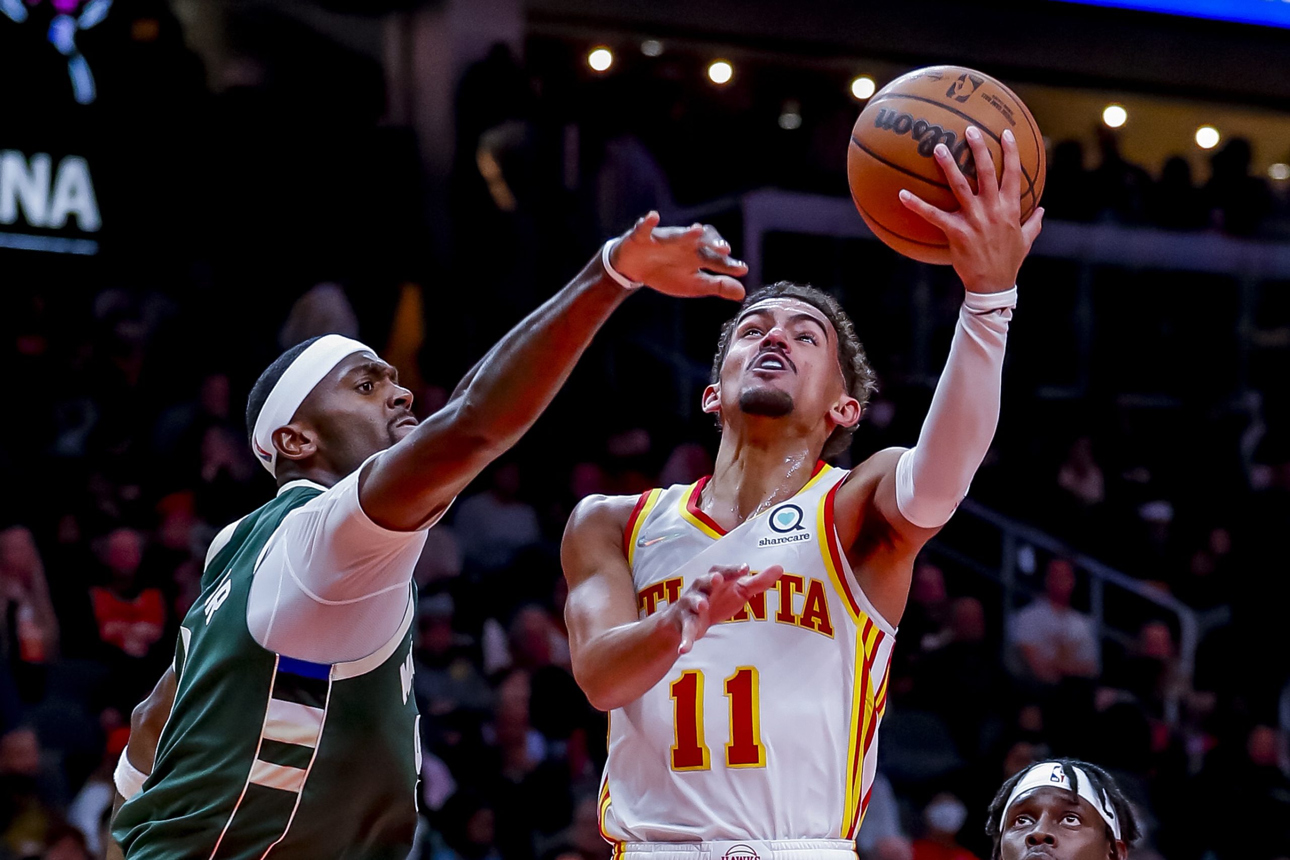 epa09582666 Atlanta Hawks guard Trae Young (R) in action against Milwaukee Bucks center Bobby Portis (L) during the second half of the NBA basketball game between the Milwaukee Bucks and the Atlanta Hawks at State Farm Arena in Atlanta, Georgia, USA, 14 November 2021.  EPA/ERIK S. LESSER  SHUTTERSTOCK OUT
