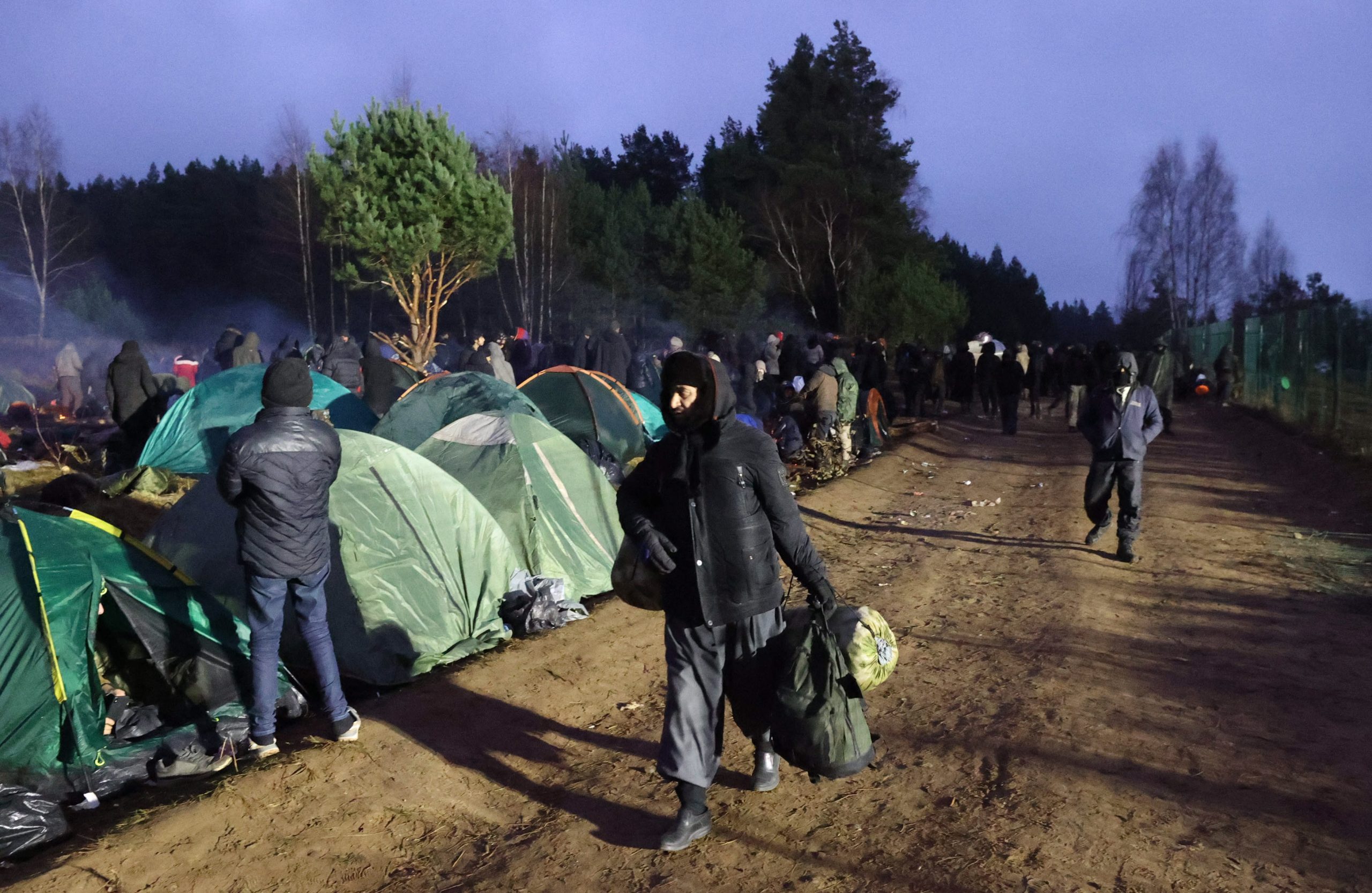 epa09588732 A handout photo made available by BelTA shows people at a camp at the Belarusian-Polish border near the Bruzgi-Kuznica Bialostocka border crossing, in the Grodno region, Belarus, 18 November 2021. Asylum-seekers, refugees and migrants from the Middle East arrived at the Belarusian-Polish checkpoint of Bruzgi-Kuznica aiming to cross the border. Thousands people who want to obtain asylum in the European Union have been trapped at low temperatures at the border since 08 November.  EPA/MAXIM GUCHEK/BELTA HANDOUT -- MANDATORY CREDIT -- HANDOUT EDITORIAL USE ONLY/NO SALES