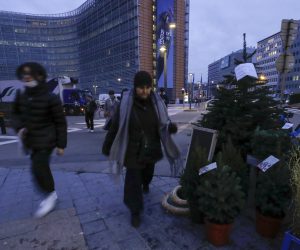 epa09598521 People wearing face masks walk at the European district in the morning as a fourth wave of Covid hits, in Brussels, Belgium, 23 November 2021. Last week Belgian Government decided to make teleworking mandatory for four days a week as Covid-19 hits Belgium with a fourth wave.  EPA/OLIVIER HOSLET