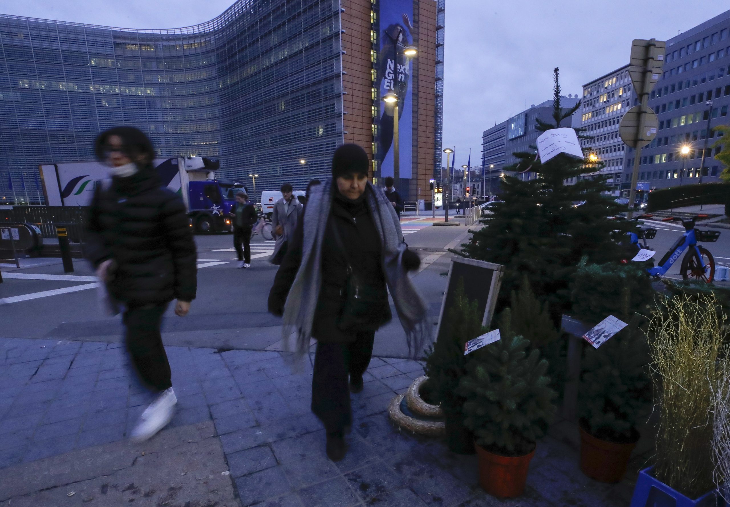 epa09598521 People wearing face masks walk at the European district in the morning as a fourth wave of Covid hits, in Brussels, Belgium, 23 November 2021. Last week Belgian Government decided to make teleworking mandatory for four days a week as Covid-19 hits Belgium with a fourth wave.  EPA/OLIVIER HOSLET