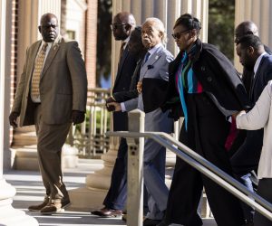 epa09600902 Al Sharpton arrives with Ahmaud Arbery's parents, Wanda Cooper-Jones (left) and Marcus Arbery (Right), at the Glynn County Courthouse as the trial of Travis McMichael, Greg McMichael and Roddie Bryan continues for the death of black jogger Ahmaud Arbery in Brunswick, Georgia, USA, 24 November 2021. Arbery died after a confrontation in the Satilla Shores neighborhood of Brunswick  on 23 February 2020.  EPA/JAMES GILBERT