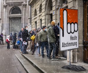 epa09608576 People queue under the snow to cast their ballot at a polling station during a referendum in Fribourg, Switzerland, Sunday, November 28, 2021. Swiss voters decide on the future of the controversial Covid certificate in a nationwide referendum.  EPA/JEAN-CHRISTOPHE BOTT