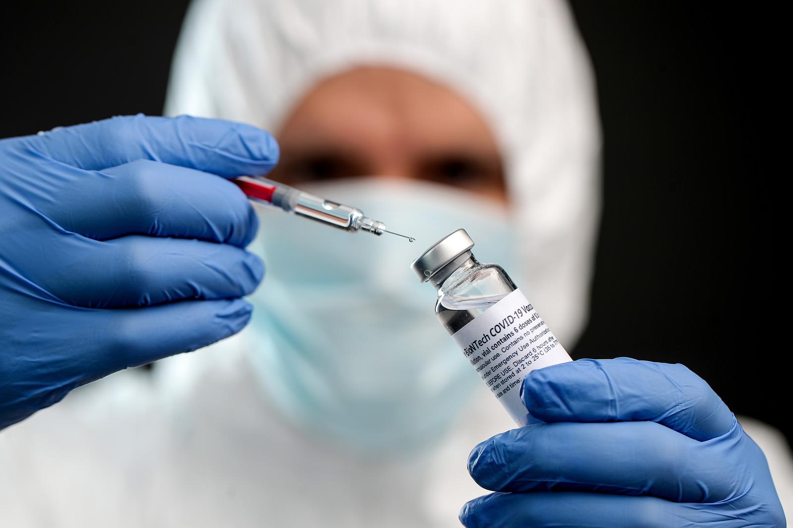 08.11.2021., Zagreb - Ilustrativna fotografija cjepiva protiv bolesti COVID-19 proizvodjaca Pfizer/BioNTech. Zdravstveni djelatnik u zastitnom odijelu i gumenik rukavicama rukuje s bocicom koja predstavlja cijepivo protiv COVID-a