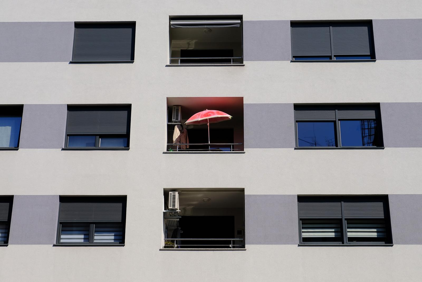 09.04.2020., Zagreb - Usamljeni crveni suncobran na balkonu moderne stambene zgrade. 
Photo: Tomislav Miletic/PIXSELL