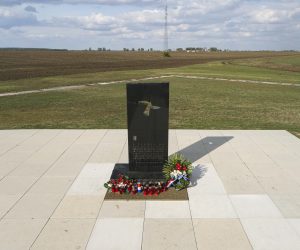 12.10.2021., Vukovar -  Pet kilometara jugoistocno od Vukovara nalazi se farma Ovcara koja je u suvremenoj hrvatskoj povijesti ostala zapamcena kao mjesto najveceg zlocina u Domovinskom ratu.
Hangar koji je u mirnodopsko vrijeme sluzio kao skladiste poljoprivredne mehanizacije od rujna 1991. godine pretvoren je u logor za nesrpsko stanovnistvo grada i okolice. U hangaru je 20. studenoga dovezeno vise od 260 hrvatskih branitelja i civila iz vukovarske bolnice. Po dolasku su im oduzete dragocjenosti i osobni predmeti te su krenula premlacivanja i torture. Prezivjeli su u vecernjim i nocnim satima istoga dana vozeni na lokaciji udaljenu oko jedan kilometar od hangara gdje ih je usred oranice cekala iskopana jama. Njih 200 smaknuto je hicima i zakopano bez ikakvog obiljezja. Danas se na mjestu hangara nalazi Spomen dom Ovcara koji cuva sjecanje na ranjenike i civile odvedene iz vukovarske bolnice, zatvorene i mucene u bivsem hangaru, a potom pogubljene i zakopane. Pokolj na Ovcari, odnosno pokolj u Vukovaru, bio je ratni zlocin koji su pocinili pripadnici JNA i srpskih paravojnih postrojba u noci s 20. na 21. studenoga 1991. godine tijekom srpske okupacije Vukovara. Tada je ubijeno izmedju 255 i 264 civila i vojnika, uglavnom Hrvata.To je bio najveci pojedinacni pokolj Domovinskog rata.  Medju ubijenima su bili francuski ratni dragovoljac Jean-Michel Nicolier i hrvatski novinar Sinisa Glavasevic.