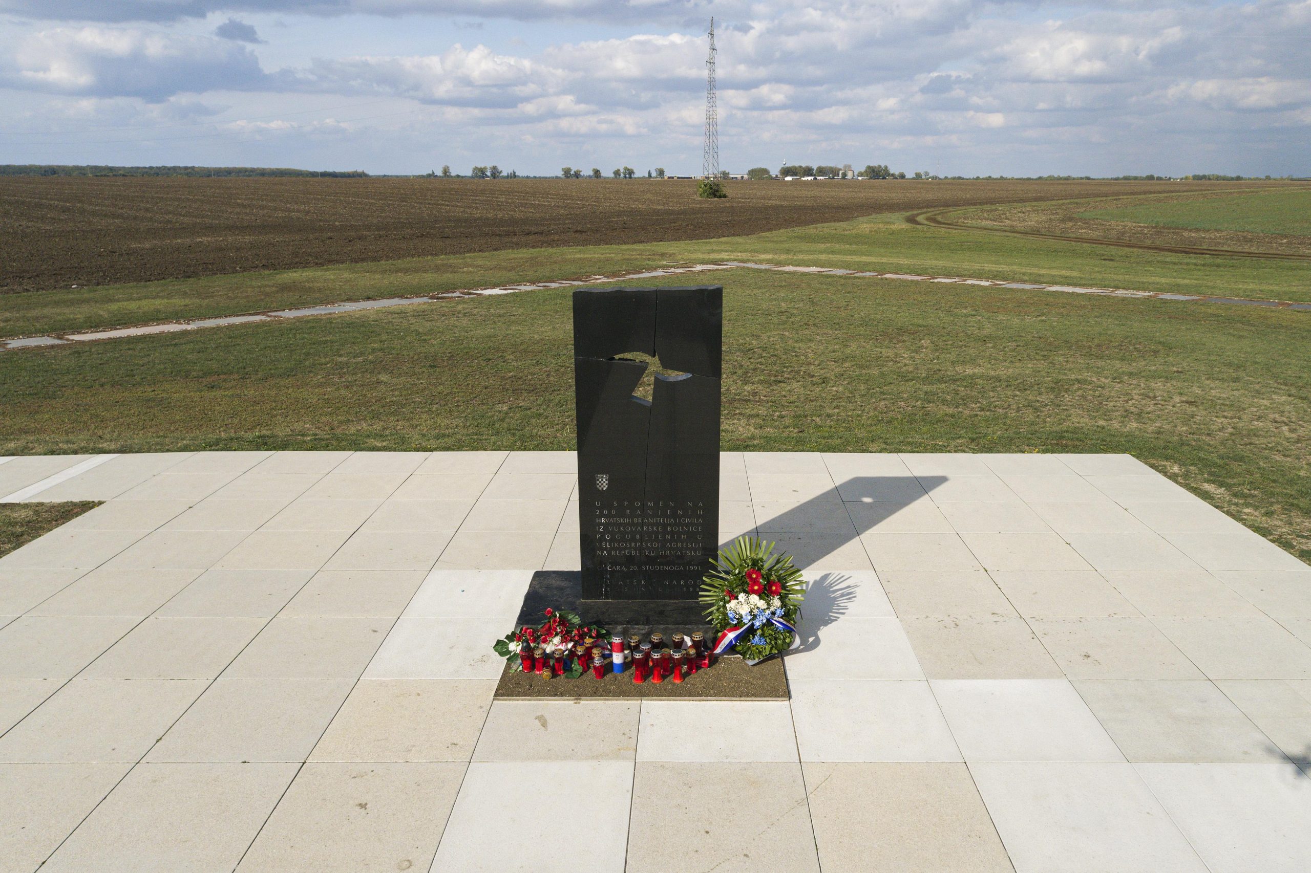 12.10.2021., Vukovar -  Pet kilometara jugoistocno od Vukovara nalazi se farma Ovcara koja je u suvremenoj hrvatskoj povijesti ostala zapamcena kao mjesto najveceg zlocina u Domovinskom ratu.
Hangar koji je u mirnodopsko vrijeme sluzio kao skladiste poljoprivredne mehanizacije od rujna 1991. godine pretvoren je u logor za nesrpsko stanovnistvo grada i okolice. U hangaru je 20. studenoga dovezeno vise od 260 hrvatskih branitelja i civila iz vukovarske bolnice. Po dolasku su im oduzete dragocjenosti i osobni predmeti te su krenula premlacivanja i torture. Prezivjeli su u vecernjim i nocnim satima istoga dana vozeni na lokaciji udaljenu oko jedan kilometar od hangara gdje ih je usred oranice cekala iskopana jama. Njih 200 smaknuto je hicima i zakopano bez ikakvog obiljezja. Danas se na mjestu hangara nalazi Spomen dom Ovcara koji cuva sjecanje na ranjenike i civile odvedene iz vukovarske bolnice, zatvorene i mucene u bivsem hangaru, a potom pogubljene i zakopane. Pokolj na Ovcari, odnosno pokolj u Vukovaru, bio je ratni zlocin koji su pocinili pripadnici JNA i srpskih paravojnih postrojba u noci s 20. na 21. studenoga 1991. godine tijekom srpske okupacije Vukovara. Tada je ubijeno izmedju 255 i 264 civila i vojnika, uglavnom Hrvata.To je bio najveci pojedinacni pokolj Domovinskog rata.  Medju ubijenima su bili francuski ratni dragovoljac Jean-Michel Nicolier i hrvatski novinar Sinisa Glavasevic.