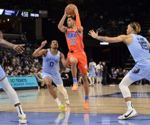 Oklahoma City Thunder guard Tre Mann (23) handles the ball between Memphis Grizzlies guard De'Anthony Melton (0) and forward Brandon Clarke (15) in the first half of an NBA basketball game Thursday, Dec. 2, 2021, in Memphis, Tenn. (AP Photo/Brandon Dill)