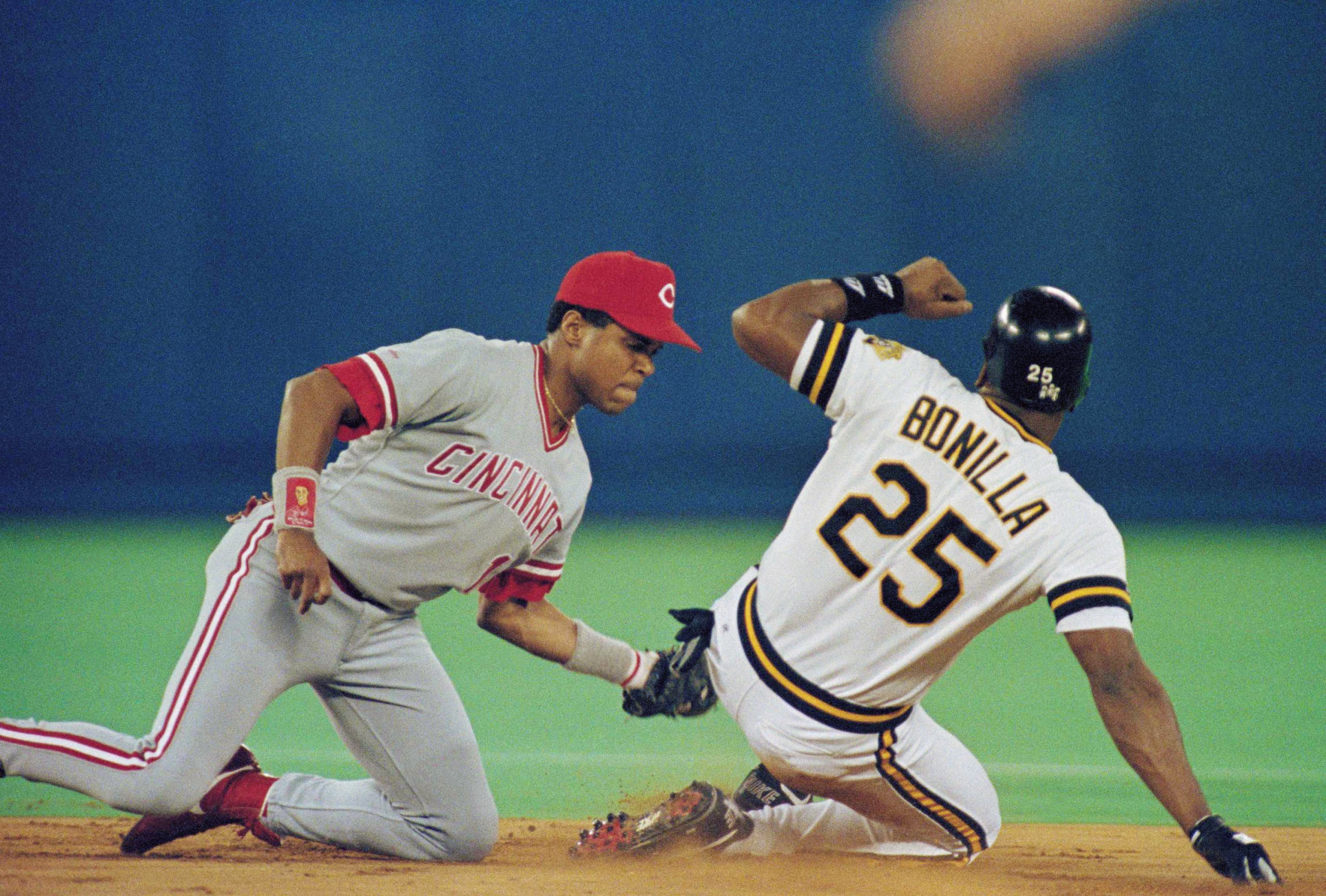 Cincinnati Reds' Barry Larkin, left, tags out Pirates right fielder Bobby Bonilla attempting to steal second base in the first inning of the National League Championship Series in Pittsburgh, Tuesday, Oct. 9, 1990. (AP Photo/Gene Puskar)