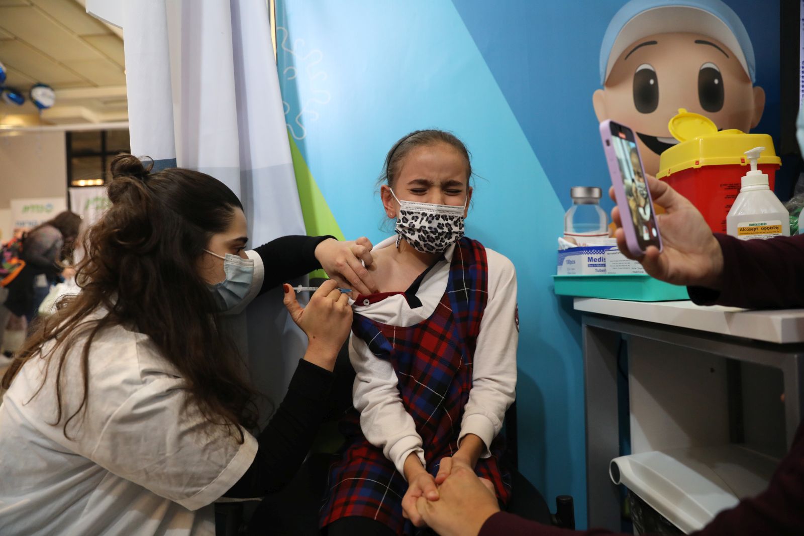 epa09598875 A nurse injects a child with a first shot of a COVID-19 vaccine in Jerusalem, Israel, 23 November 2021. Israel launched a campaign to offer Covid-19 vaccine dose for children between 5 and 12 years old  EPA/ABIR SULTAN