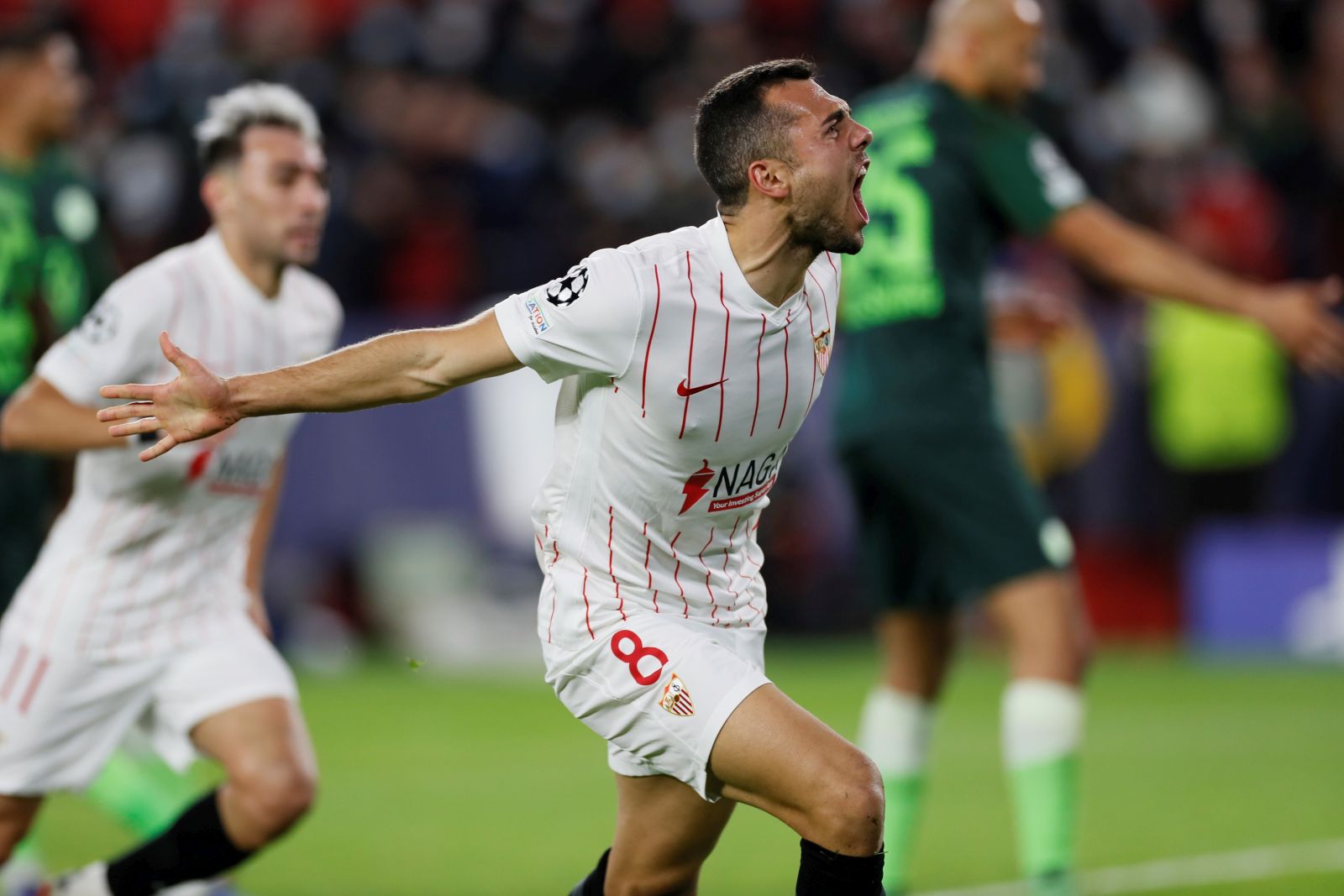 epa09599690 Sevilla's midfielder Joan Jordan (R) celebrates after scoring his team's first goal against Wolfsburg during the UEFA Champions League match played in Ramon Sanchez Pizjuan stadium in Sevilla, southern Spain, 23 November 2021.  EPA/Jose Manuel Vidal