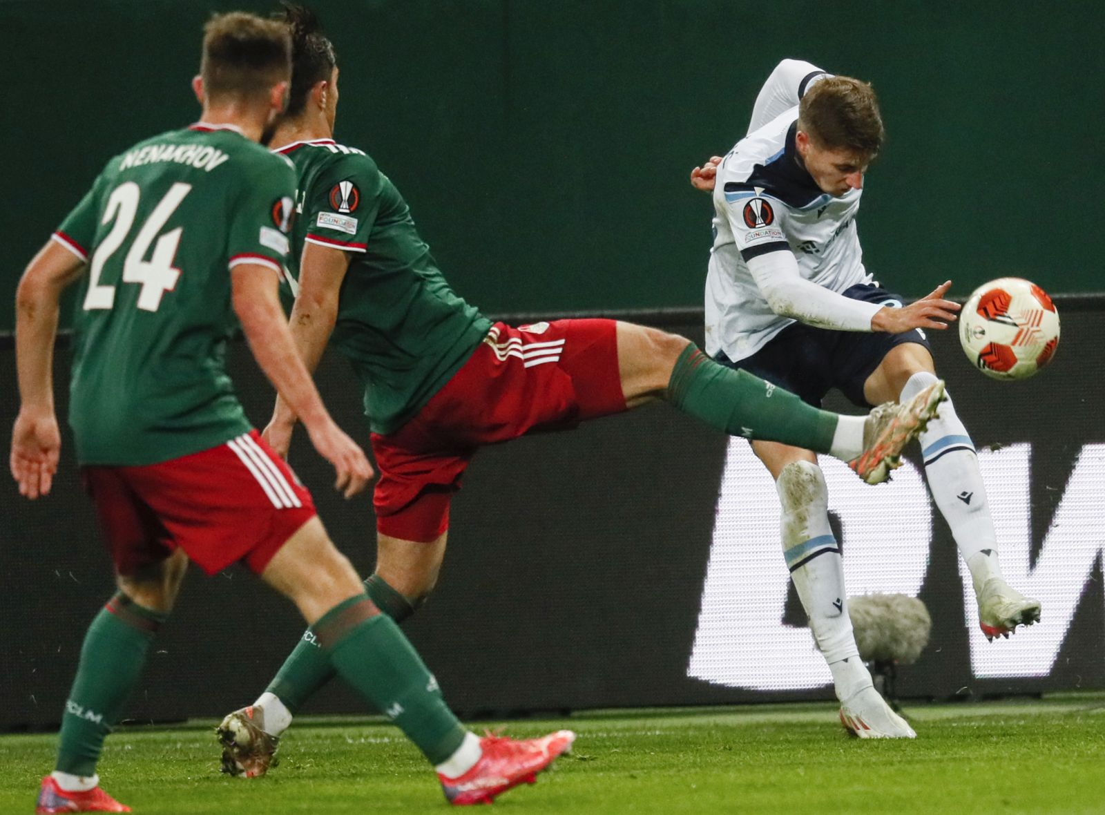 epa09603003 Maksim Nenakhov (L) and Konstantin Maradishvili (C) of Lokomotiv Moscow in action against Toma Basic (R) of Lazio during the UEFA Europa League group E soccer match between FK Lokomotiv Moscow and SS Lazio at the Lokomotiv Stadium in Moscow, Russia, 25 November 2021.  EPA/YURI KOCHETKOV