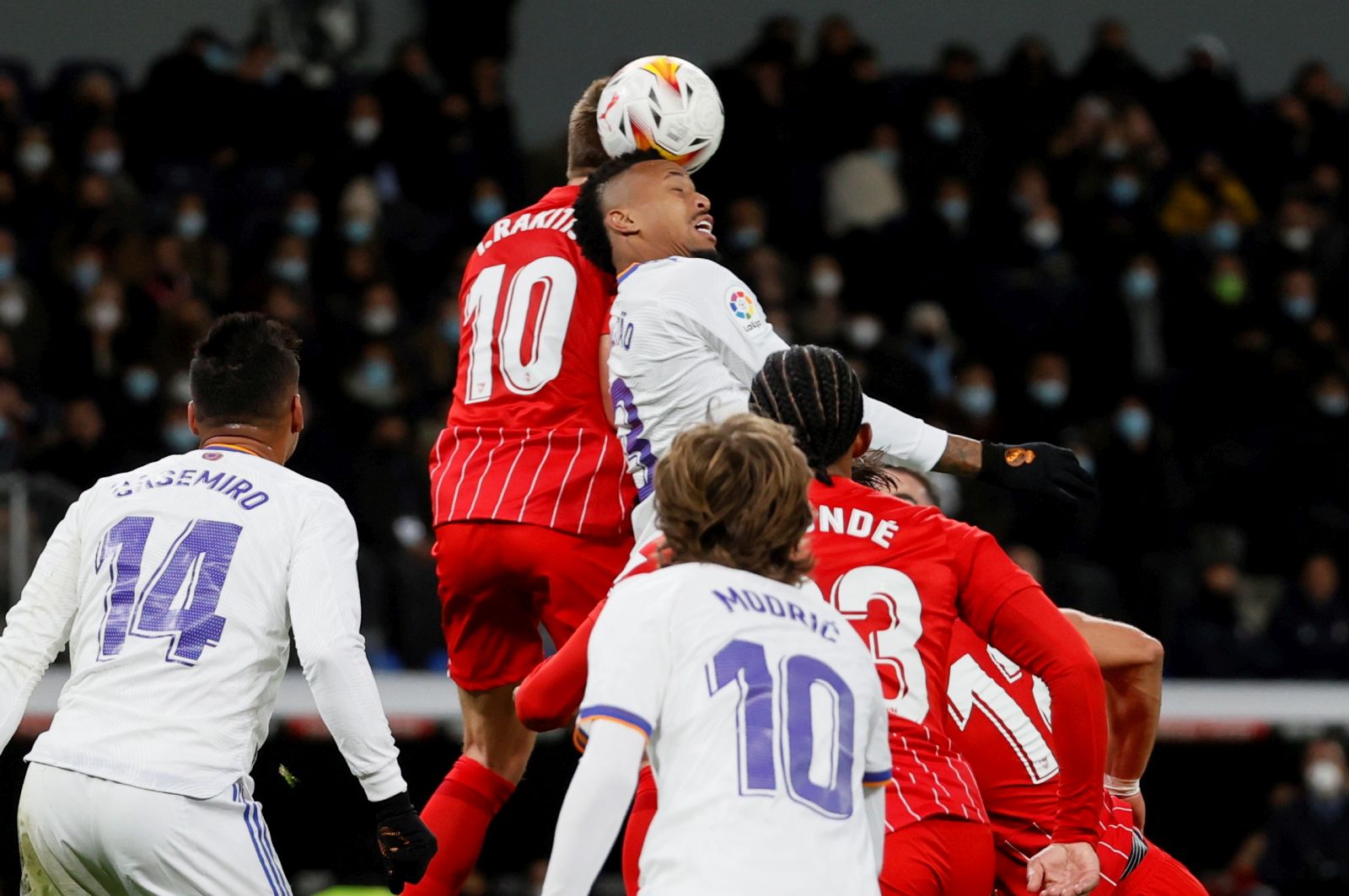 epa09610077 Real Madrid's Eder Gabriel Militao (3-L) heads for the ball with Sevilla's Ivan Rakitic (2-L) during the Spanish LaLiga soccer match between Real Madrid and Sevilla FC at Santiago Bernabeu stadium in Madrid, Spain 28 November 2021.  EPA/Ballesteros