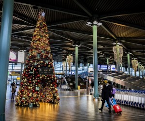 epa09612537 People at Schiphol Airport wear face masks as they walk in a seasonal decorated terminal of the airport near Amsterdam, The Netherlands, 30 November 2021. Travelers from South Africa are tested for the Coronavirus Omicron variant upon arrival in a specially designed test lane at the Schiphol airport, The Netherlands, 30 November 2021. It was decided to set up the test street after the so-called Omicron variant of the coronavirus was found in southern Africa.  EPA/REMKO DE WAAL