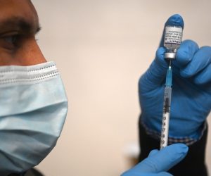 epa09618789 A pharmacy worker prepares a Covid-19 booster jab at the St John's Church Vaccination Centre in London Britain, 03 December 2021. A UK trial of seven different jabs finds that Pfizer and Moderna vaccines give the best overall booster response. A year ago the UK was the first country to approve the Pfizer-BioNTech vaccine.  EPA/NEIL HALL