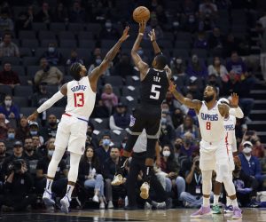 epa09622876 Sacramento Kings guard De'Aaron Fox (C) shoots a three point basket over LA Clippers guard Paul George (L) as LA Clippers forward Marcus Morris Sr. (R) looks on during the first half of their NBA game at the Golden 1 Center in Sacramento, California, USA, 04 December 2021.  EPA/JOHN G. MABANGLO  SHUTTERSTOCK OUT