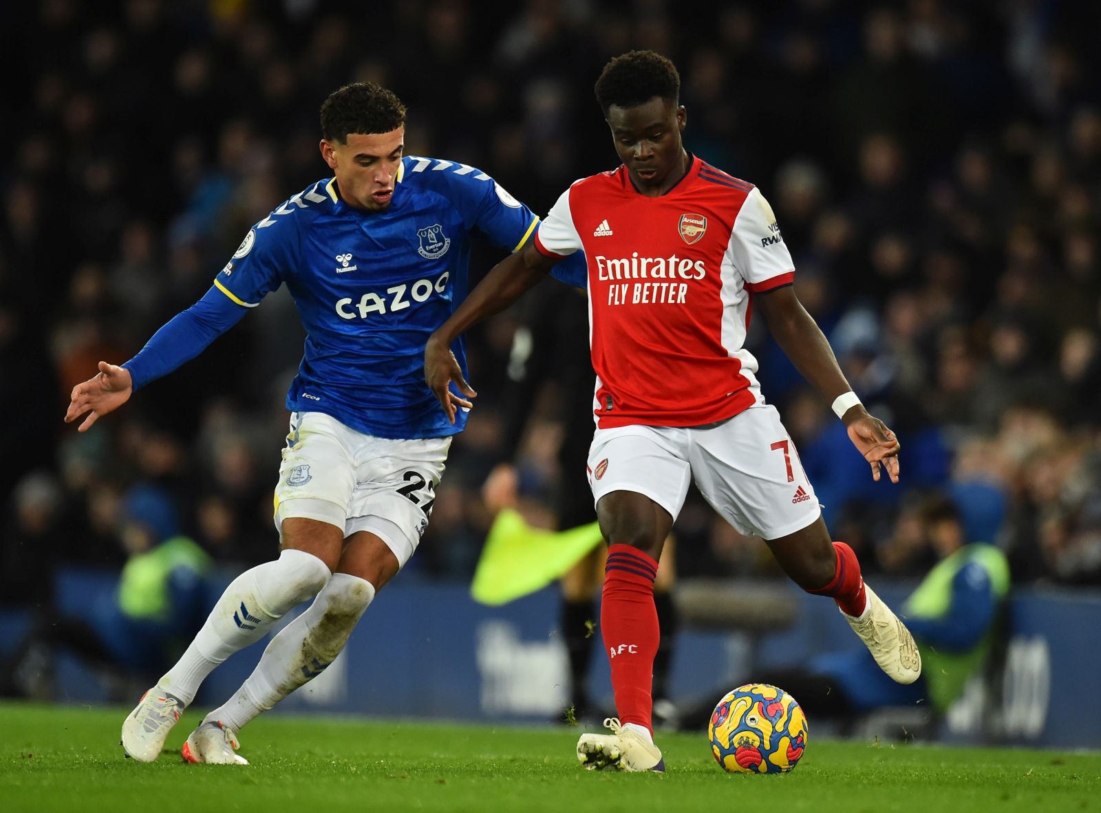 epa09626239 Ben Godfrey of Everton (L) in action against Bukayo Saka of Arsenal (R) during the English Premier League soccer match between Everton FC and Arsenal FC in Liverpool, Britain, 06 December 2021.  EPA/PETER POWELL EDITORIAL USE ONLY. No use with unauthorized audio, video, data, fixture lists, club/league logos or 'live' services. Online in-match use limited to 120 images, no video emulation. No use in betting, games or single club/league/player publications