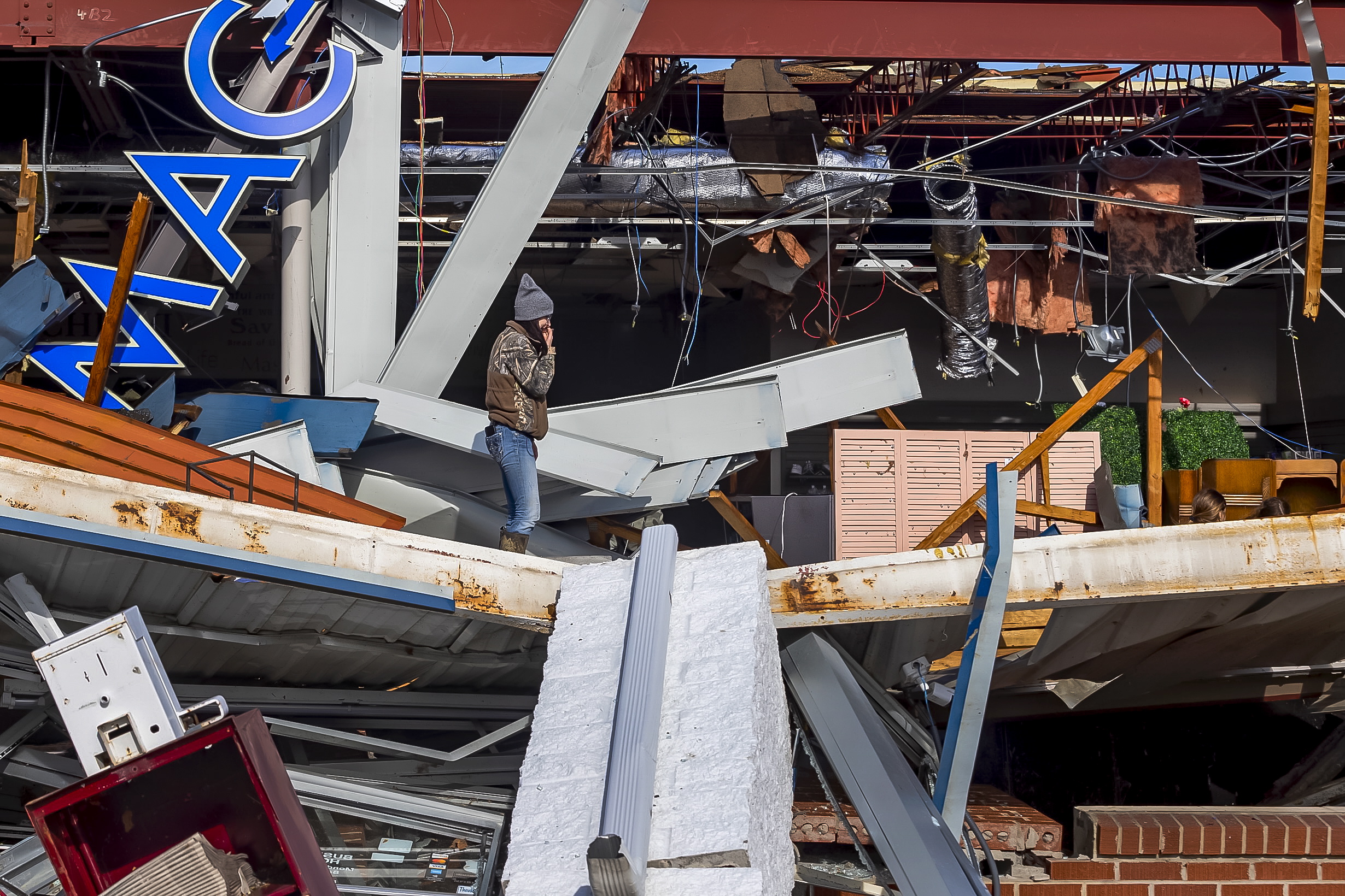 epa09637213 A resident observes damage to a business after a deadly tornado struck in Mayfield, Kentucky, USA, 11 December 2021. As many as 70 people are feared dead in Kentucky due to the tornado outbreak, according to Kentucky Governor Andy Beshear.  EPA/ADDISON LEBOUTILLIER