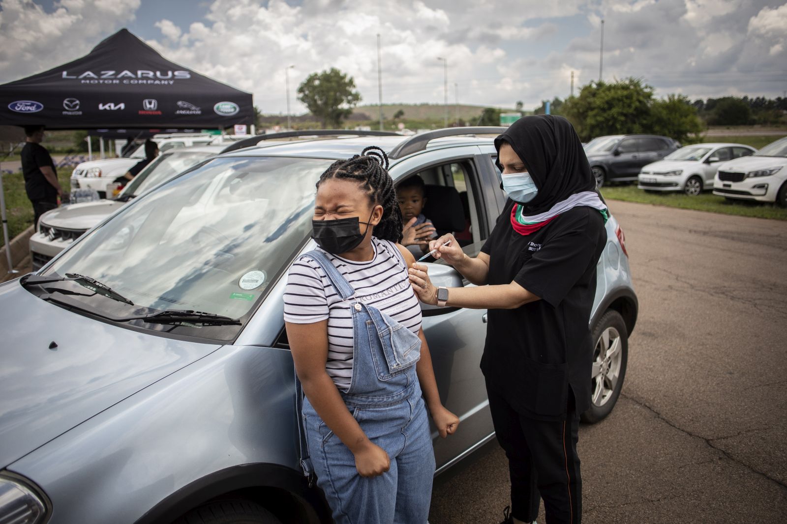epa09642812 A teenager receives a jab of Covid-19 vaccine at a drive-through vaccination facility at the Zwartkops Raceway in Pretoria, South Africa, 15 December 2021. The facility opened in an effort to increase vaccinations prior to the start of the annual end of year holidays, amid Omicron variant fears.  EPA/Kim Ludbrook