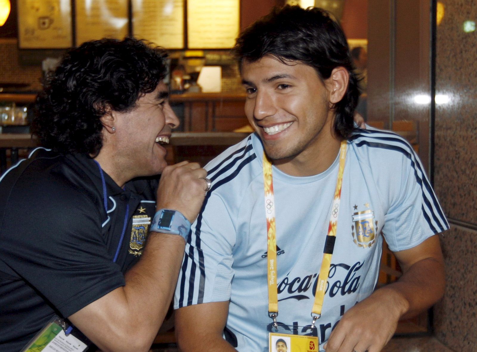 epa09642898 (FILE) - Former Argentinean soccer player Diego Armando Maradona (L) and Sergio Aguero (R) share a light moment during the 2008 Beijing Olympic Games in Beijing, China, 19 August 2008 (re-issued on 15 December 2021). Argentinian striker Sergio 'Kun' Aguero announced his retirement during a press conference in Barcelona, Spain, on 15 December 2021.  EPA/Jesus Diges
