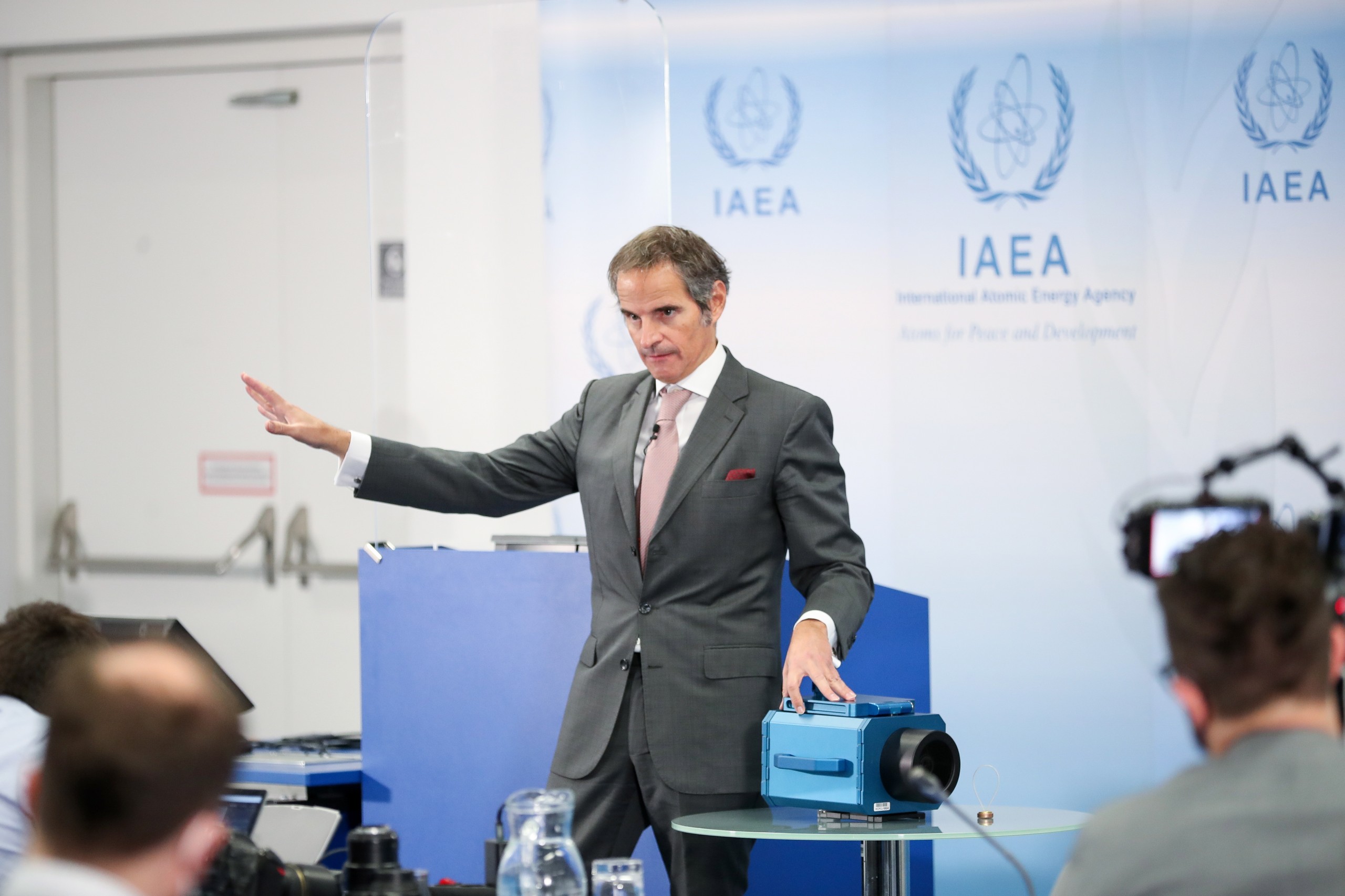 epa09646536 International Atomic Energy Agency (IAEA) Director General Rafael Mariano Grossi points at the module of a IAEA surveillance camera during a press conference at the IAEA headquarters of the UN seat in Vienna, Austria, 17 December 2021. The IAEA director general commented on the developments related to the IAEA's monitoring and verification work in the Islamic Republic of Iran.  EPA/MAX BRUCKER