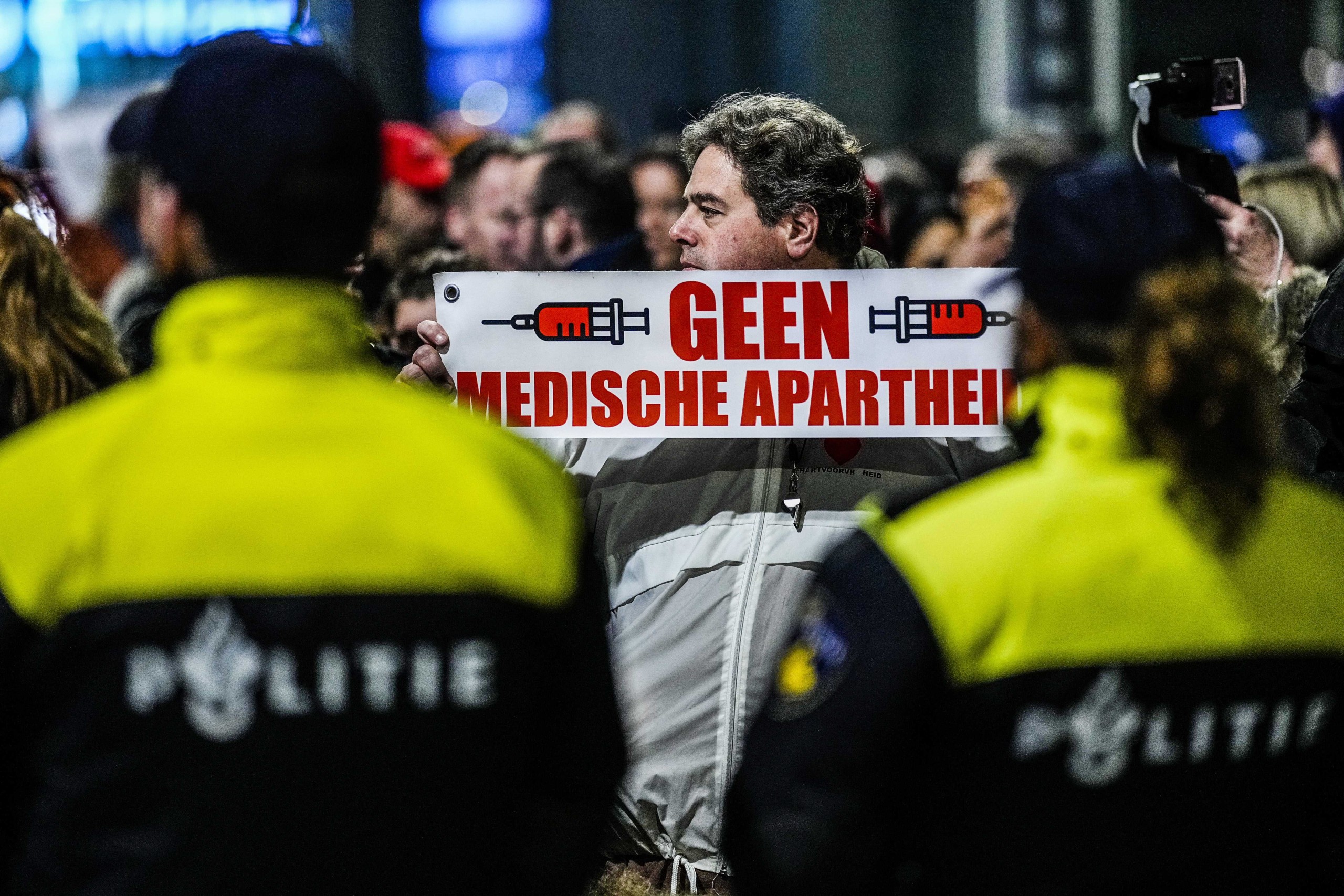 epa09648953 People protest against the Dutch government's lockdown announcement, in The Hague, the Netherlands, 18 December 2021. The Netherlands are to enter a hard lockdown starting from 19 December 2021 until at least 14 January 2022 to curb the rapid spread of the Omicron variant.  EPA/PHIL NIJHUIS