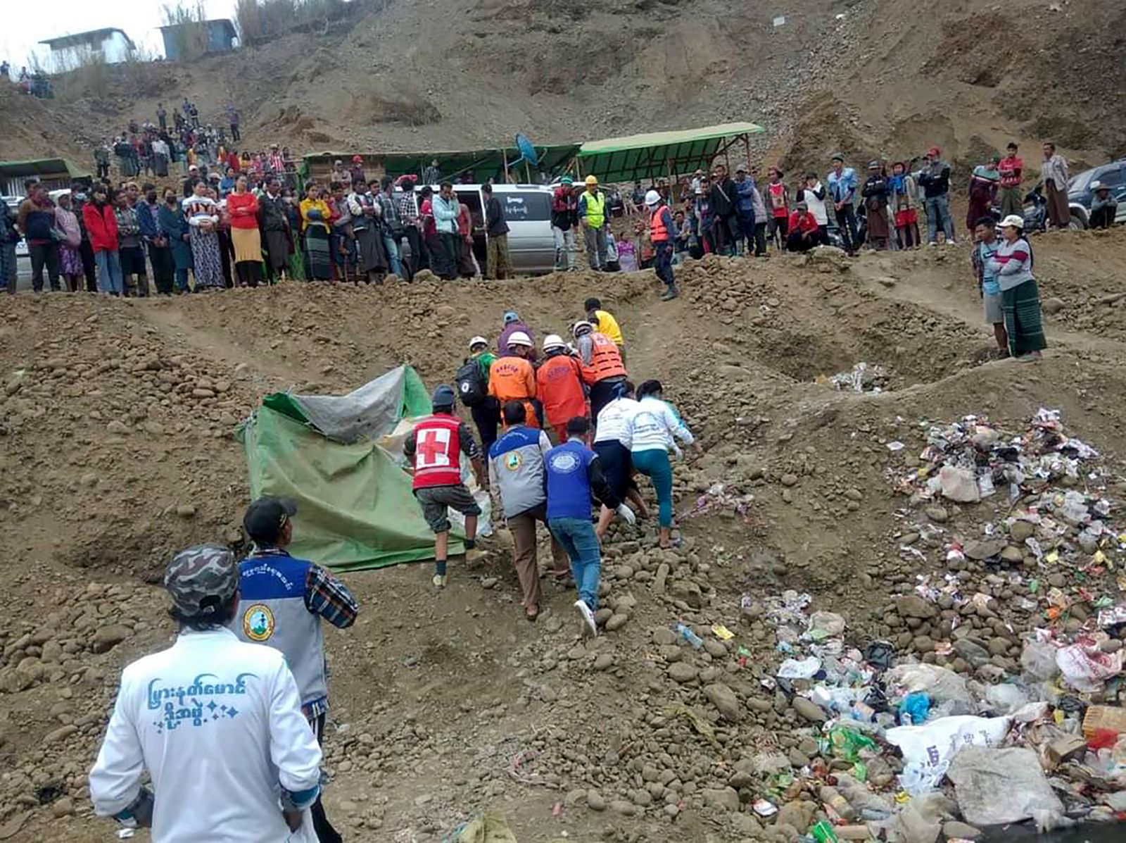 epa09653346 A handout photo made available by the Myanmar Fire Services Department shows members of fire services and rescue team search for the missing people at the accident scene of a jade mining site in Hpakant, Kachin State, northern Myanmar, 22 December 2021. According to a local rescue member from the scene, one dead body found and dozens of people missing, accident happen early in the morning.  EPA/FIRE SERVICES DEPARTMENT HANDOUT  HANDOUT EDITORIAL USE ONLY/NO SALES