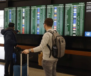 epa09656213 Travelers check out the the flight information display system at the San Francisco International Airport on Christmas Eve in San Francisco, California, USA, 24 December 2021. Thousand of flights were cancelled globally and United and and Delta Airlines cancelled over 200 flights domestically on Friday, 24 December, alone citing the personnel shortages due to the surge of Omicron variant of COVID-19 infections.  EPA-EFE/JOHN G. MABANGLO