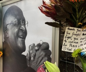 epa09657702 Flowers are seen in front of a photograph of the late Archbishop Emeritus Desmond Tutu at the St Georges Cathedral , Cape Town, South Africa, 27 December 2021. The anti apartheid activist and Nobel Peace Price winner died aged 90 at a frail care home. There will be a 7 day send-off including a state funeral, lying in state and church service at his old church.  EPA/STR