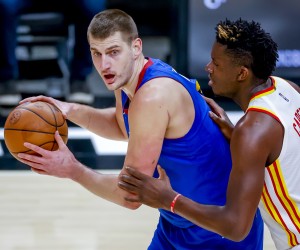 epa09647597 Denver Nuggets center Nikola Jokic (L) of Serbia in action against Atlanta Hawks center Clint Capela (R) of Switzerland during the first half of the NBA basketball game between the Denver Nuggets and the Atlanta Hawks at State Farm Arena in Atlanta, Georgia, USA, 17 December 2021.  EPA/ERIK S. LESSER SHUTTERSTOCK OUT