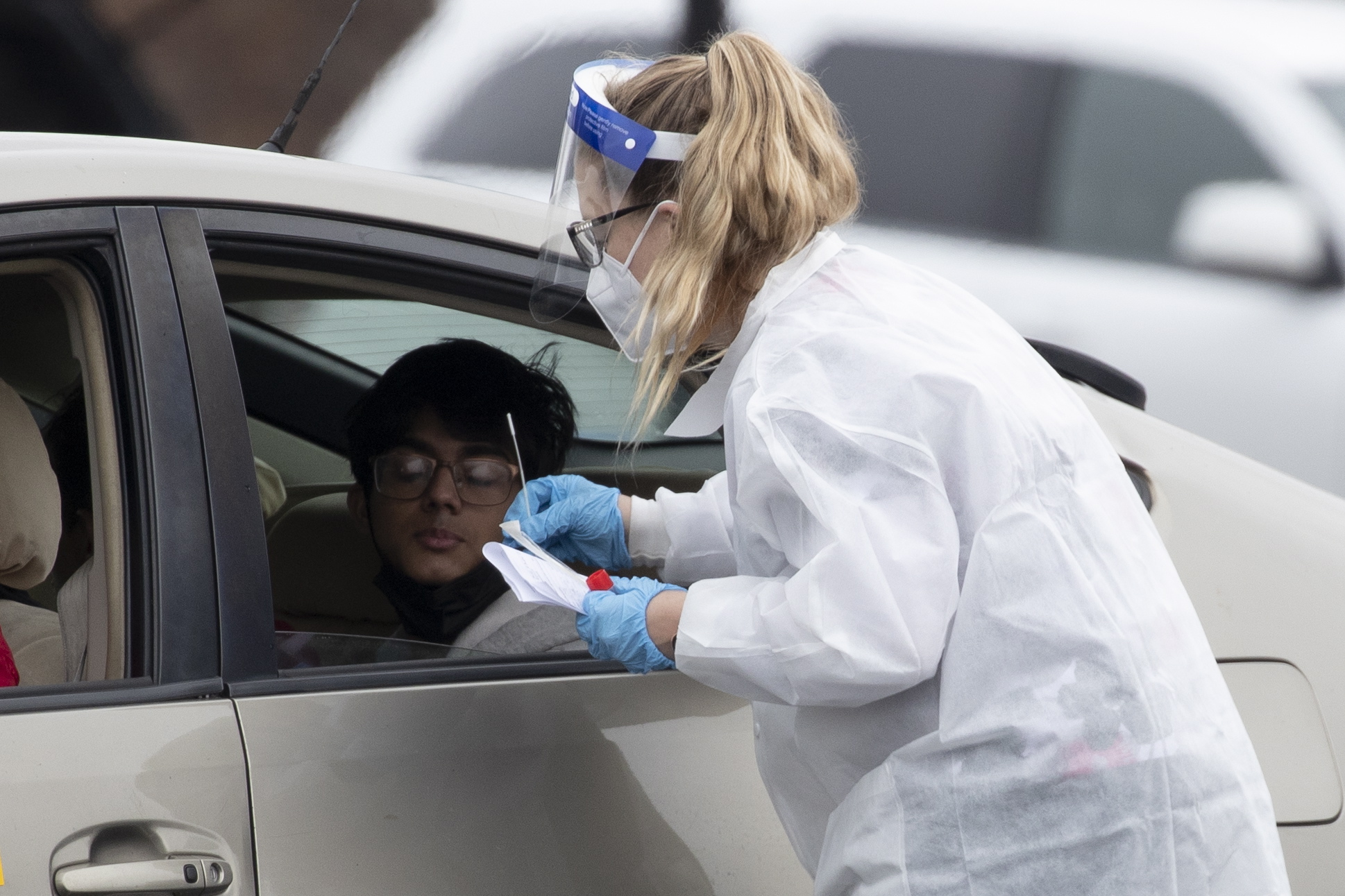 epa09660734 A Covid-19 test is administered to an individual inside a vehicle at the head of a long line at a Covid-19 drive-thru testing event in Leesburg, Virginia, USA, 30 December 2021. The Loudoun County government held a free drive-thru Covid-19 testing event that reached maximum capacity ahead of schedule, drawing hundreds of vehicles that formed a line well over a mile long with wait times over two hours for some people.  EPA/MICHAEL REYNOLDS
